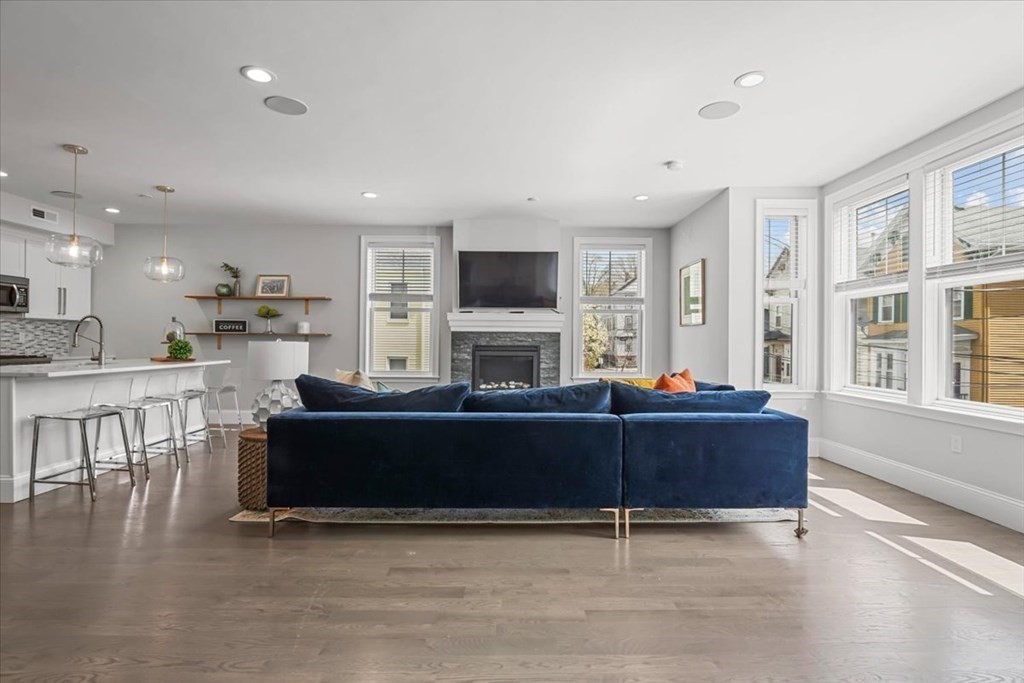 a living room with furniture a flat screen tv and a fireplace