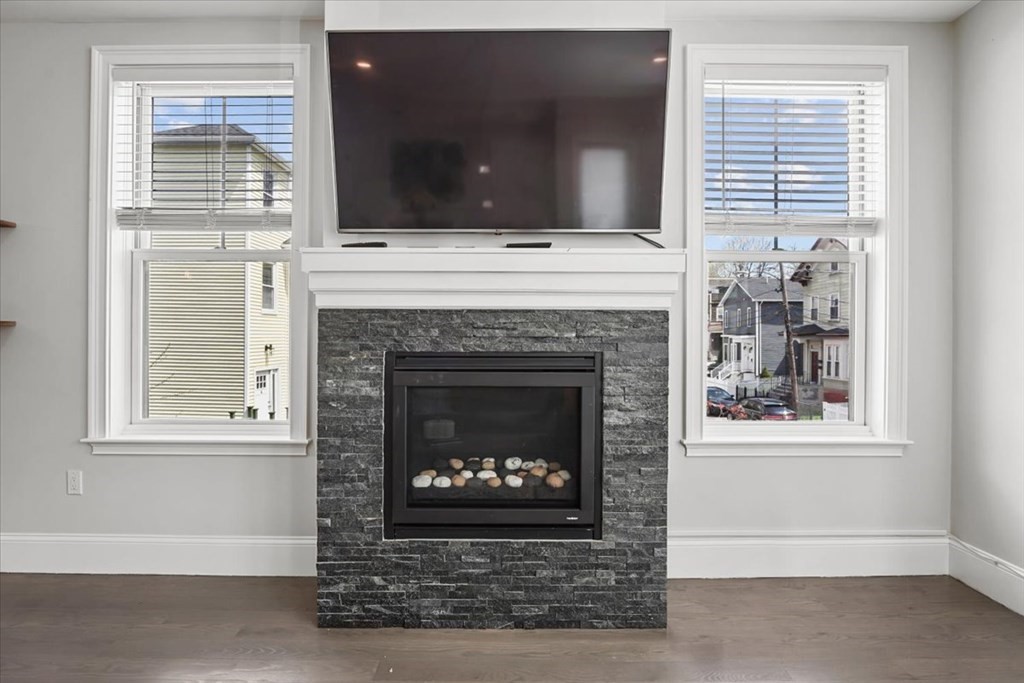 2-4 Elm Street, Unit 2B Boston, MA 02122 - Photo 8 of 27 a living room with a fireplace and a flat screen tv