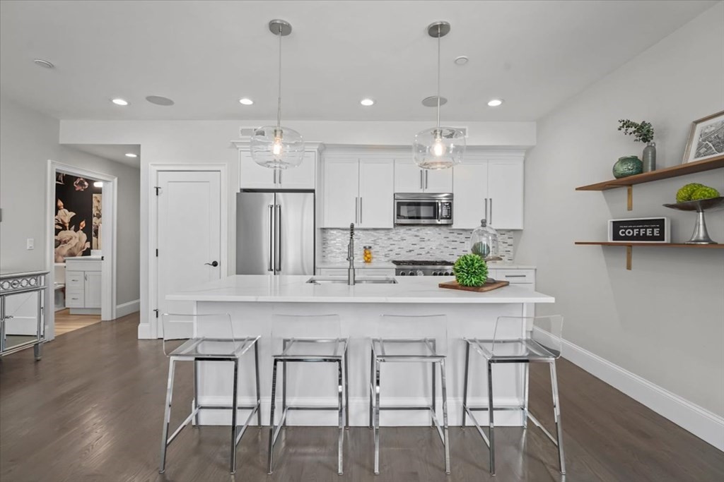 2-4 Elm Street, Unit 2B Boston, MA 02122 - Photo 9 of 27 a kitchen with kitchen island cabinets and wooden floor