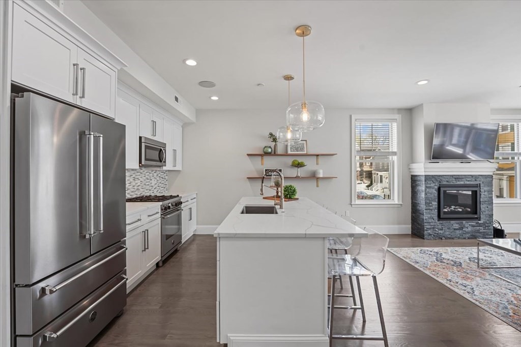 2-4 Elm Street, Unit 2B Boston, MA 02122 - Photo 10 of 27 a kitchen with kitchen island a counter top space a sink stainless steel appliances and cabinets