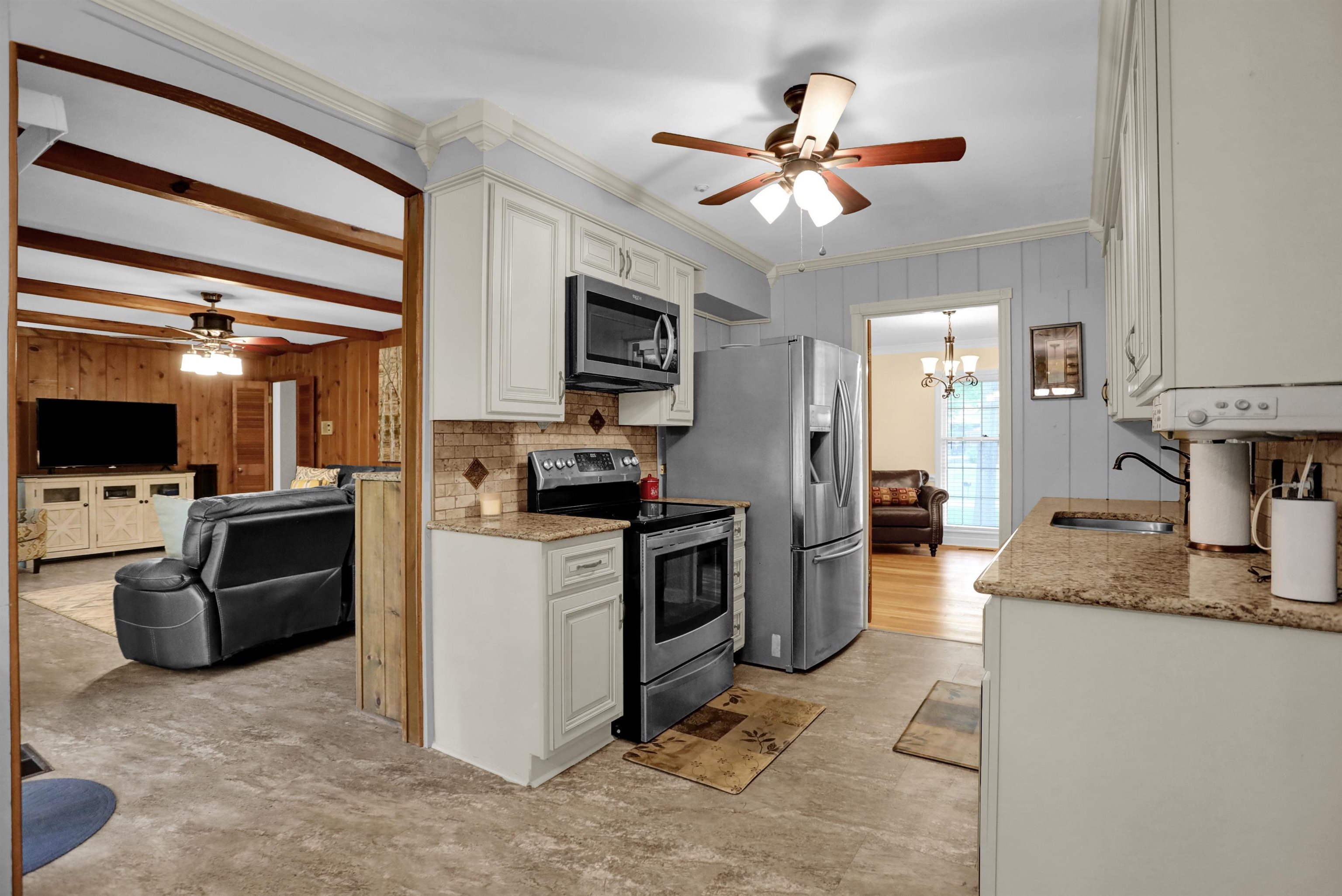 1277 Old Hickory Road Memphis, TN 38116 - Photo 27 of 29 Kitchen featuring a sink, ceiling fan with notable chandelier, wood walls, and stainless steel appliances