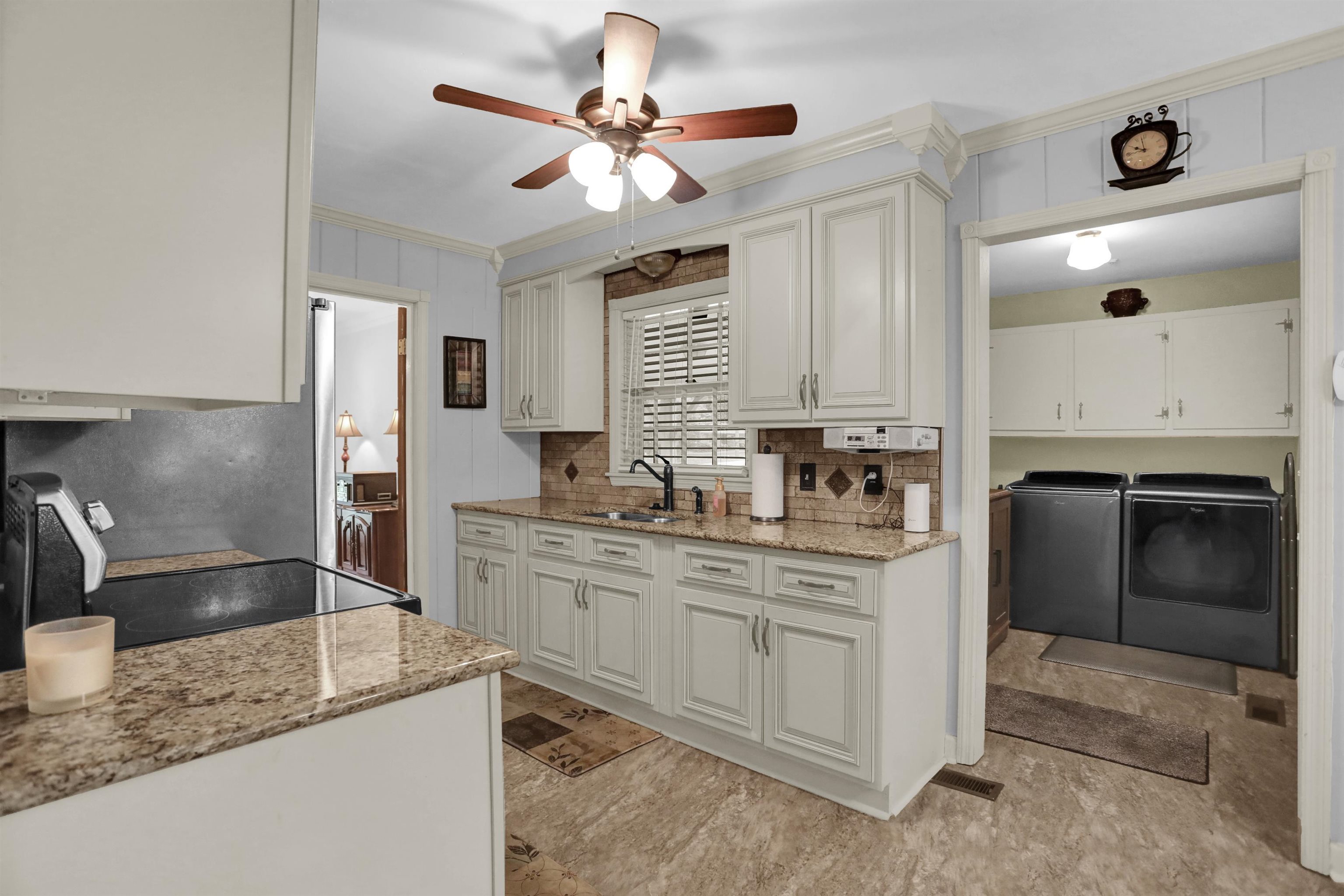 1277 Old Hickory Road Memphis, TN 38116 - Photo 5 of 29 Kitchen with crown molding, decorative backsplash, a sink, washer and dryer, and a ceiling fan