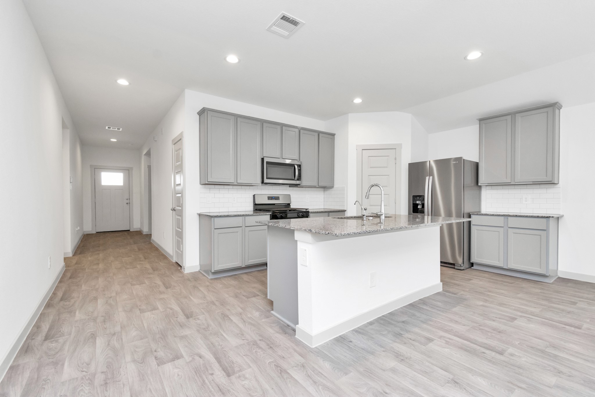 10626 Watershed Drive Rosharon, TX 77583 - Photo 25 of 42 a kitchen with white cabinets and stainless steel appliances