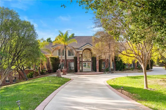 a view of a fountain in front of a house with palm trees