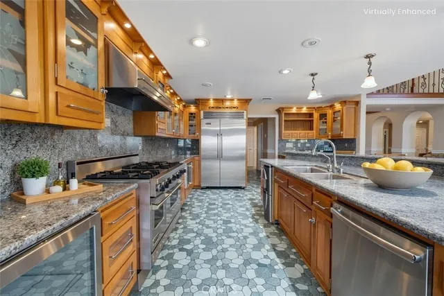 a kitchen with stainless steel appliances granite countertop a stove a sink and a refrigerator