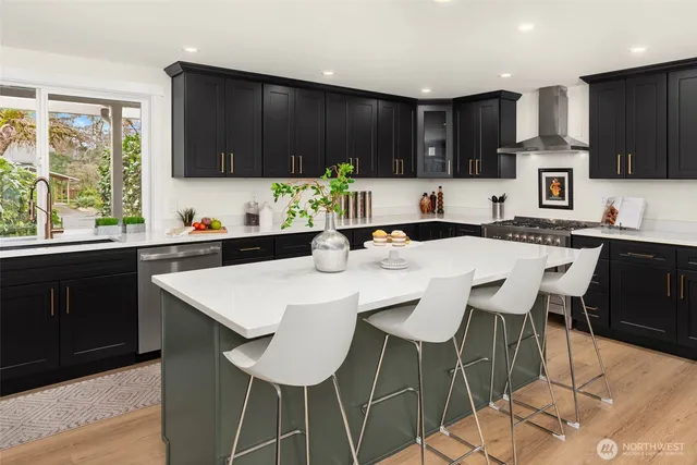 a kitchen with stainless steel appliances kitchen island granite countertop a sink and a white cabinets