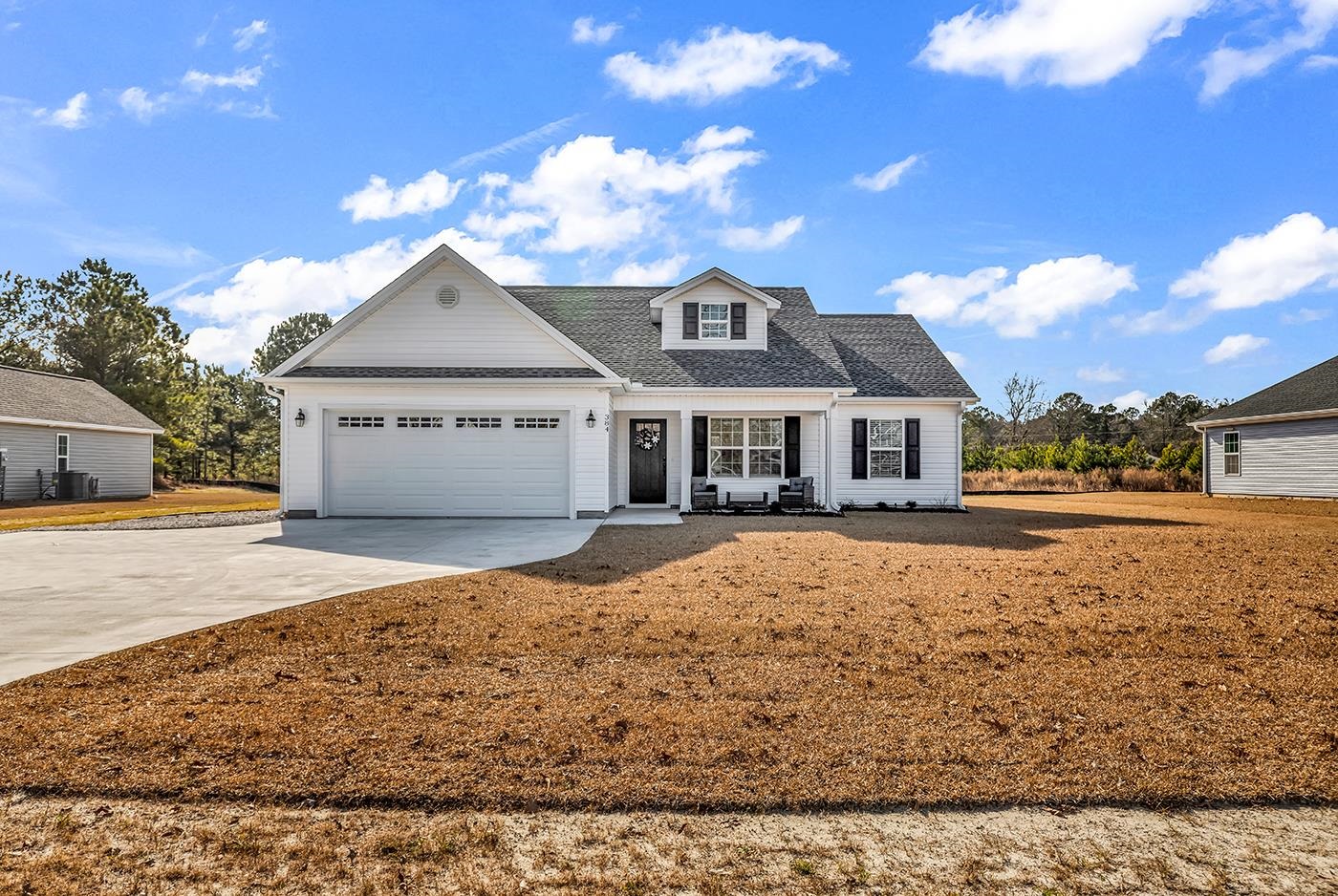 View of front of property featuring driveway, a shingled roof, and a garage