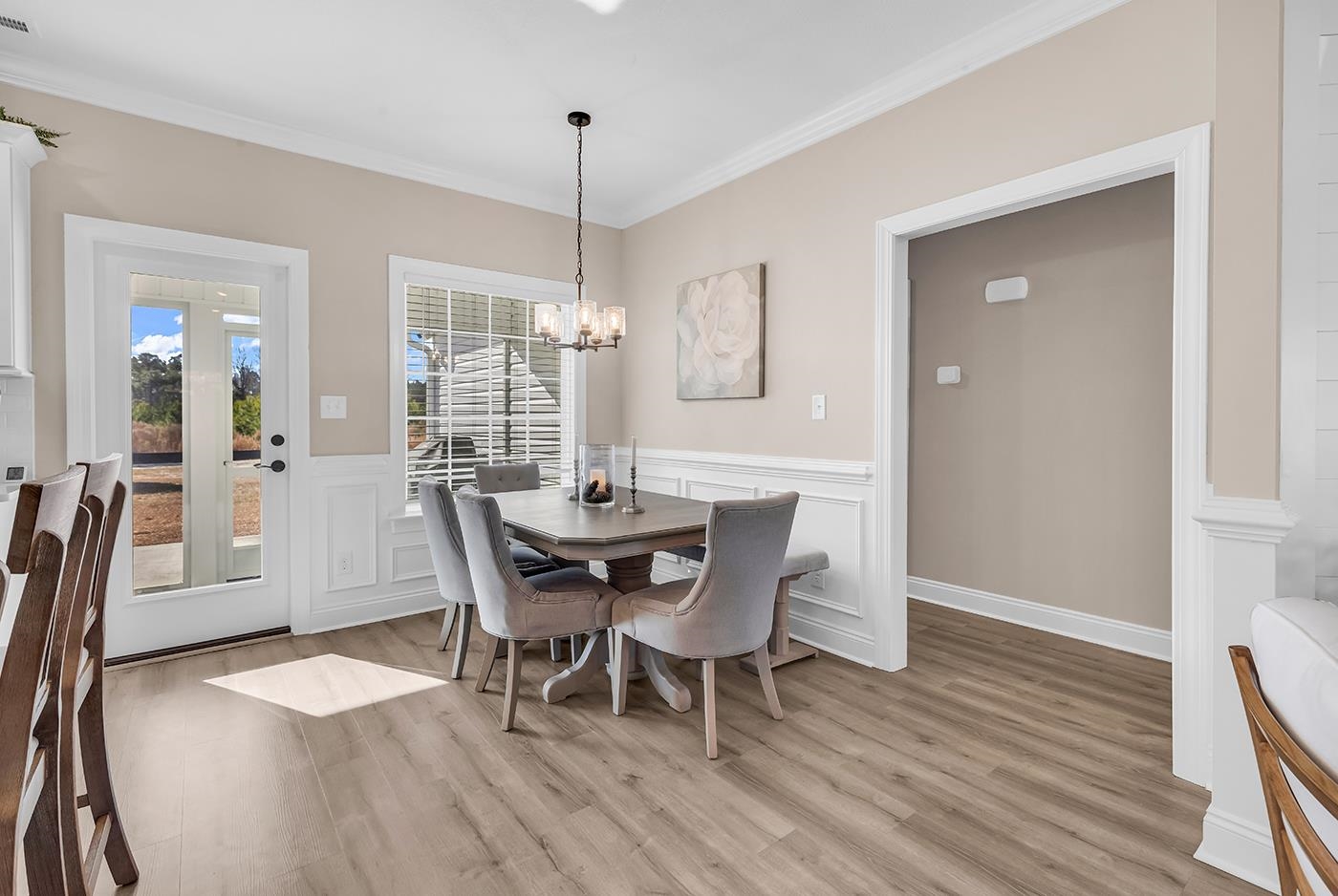 384 William Nobles Road Aynor, SC 29511 - Photo 17 of 38 Dining room featuring ornamental molding, light wood-style flooring, a chandelier, wainscoting, and a decorative wall