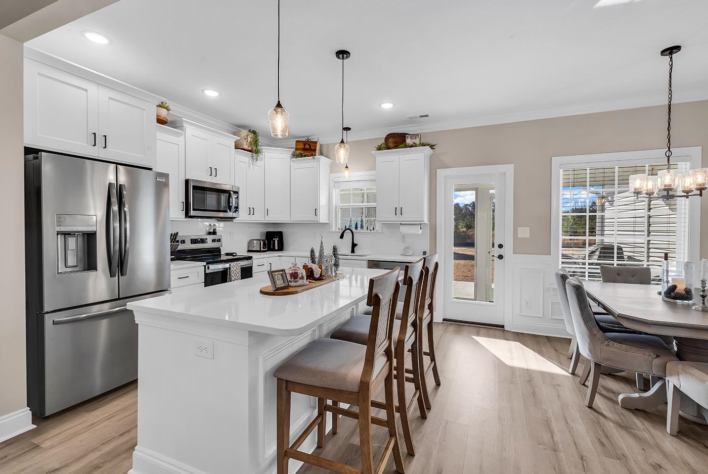 384 William Nobles Road Aynor, SC 29511 - Photo 10 of 38 Kitchen featuring stainless steel appliances, white cabinetry, wainscoting, a kitchen bar, and a center island
