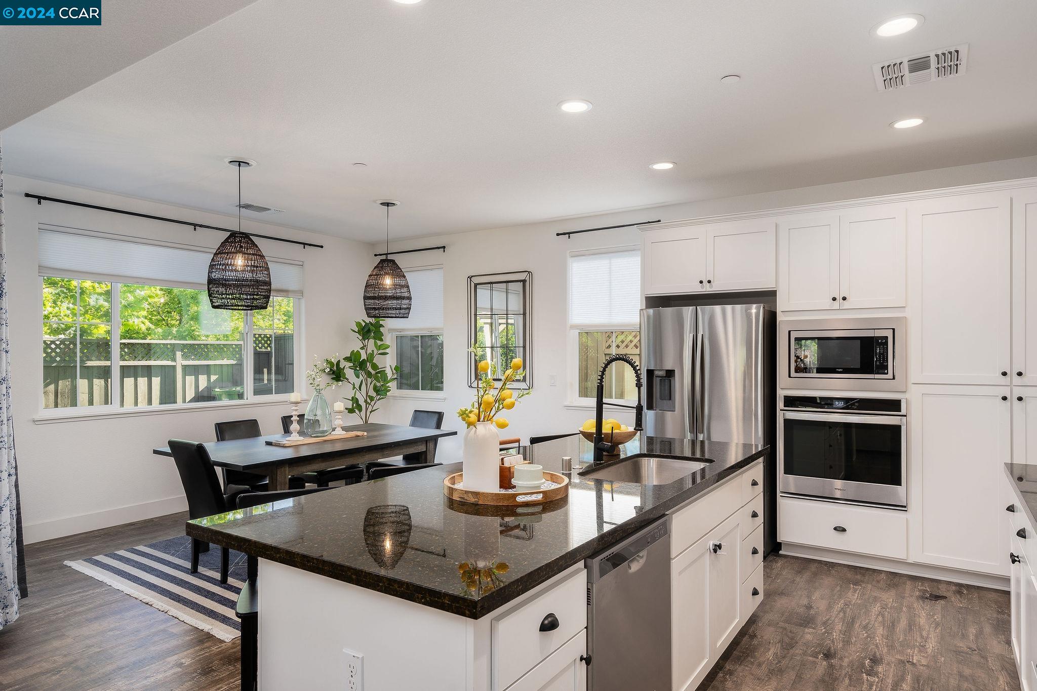 a kitchen with granite countertop a sink appliances and window