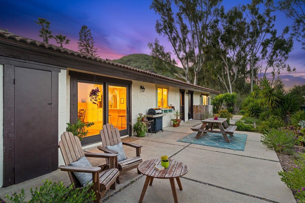 1698 Sleeping Indian Road Fallbrook, CA 92028 - Photo 1 of 1 a view of a patio with table and chairs and floor to ceiling window and potted plants