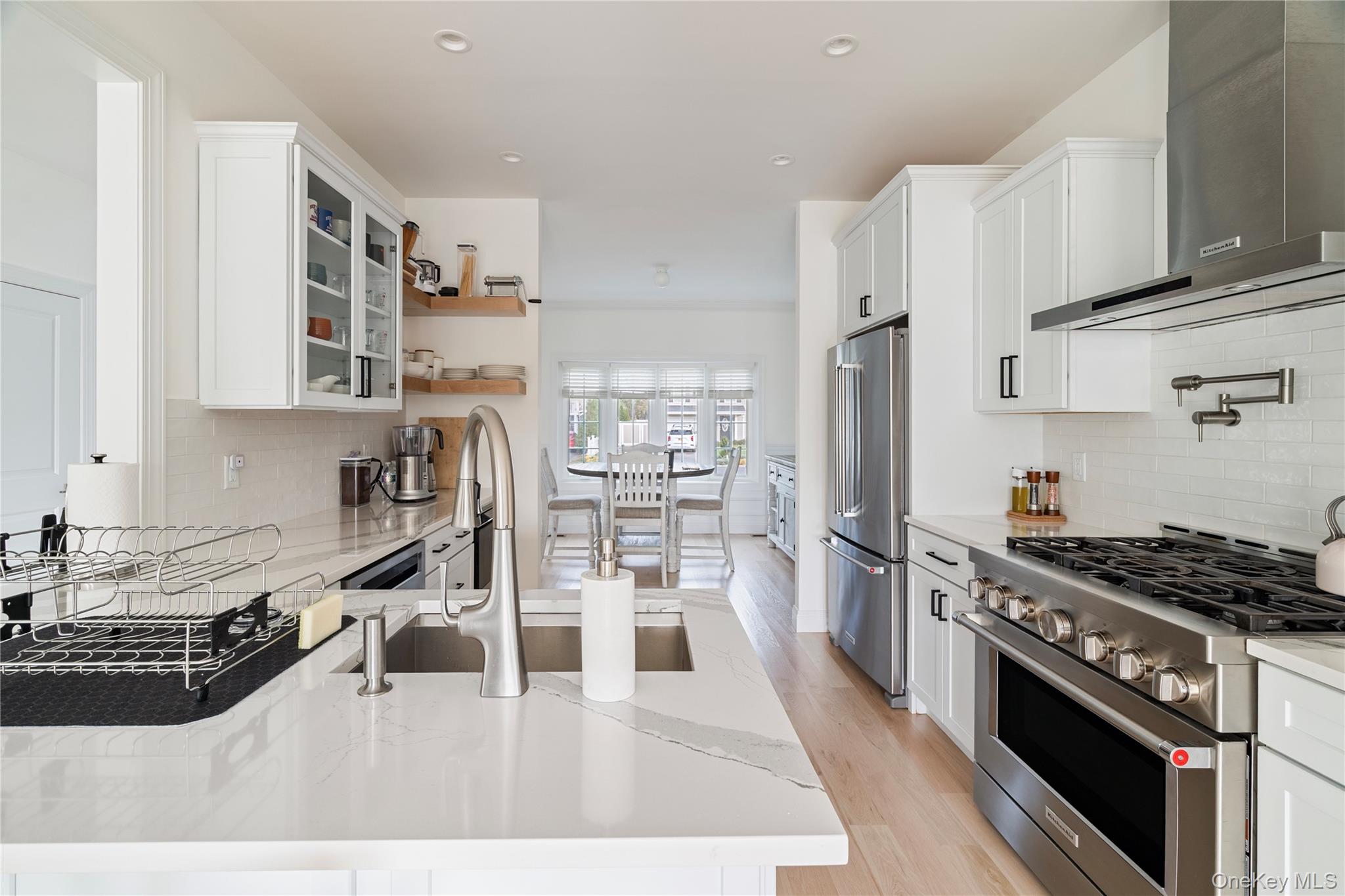 60 Parsnip Pond Road Lake Grove, NY 11755 - Photo 14 of 32 a kitchen with stainless steel appliances kitchen island wooden cabinets a stove a sink and a refrigerator