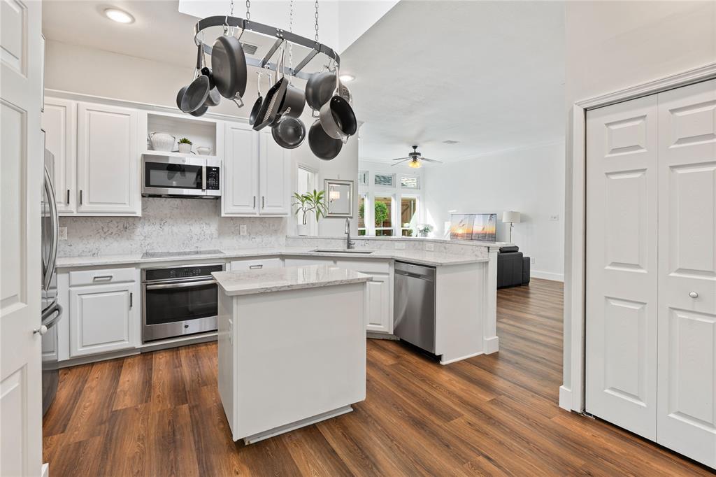 8718 Falls Road Irving, TX 75063 - Photo 11 of 28 a kitchen with a white cabinets and wooden floor
