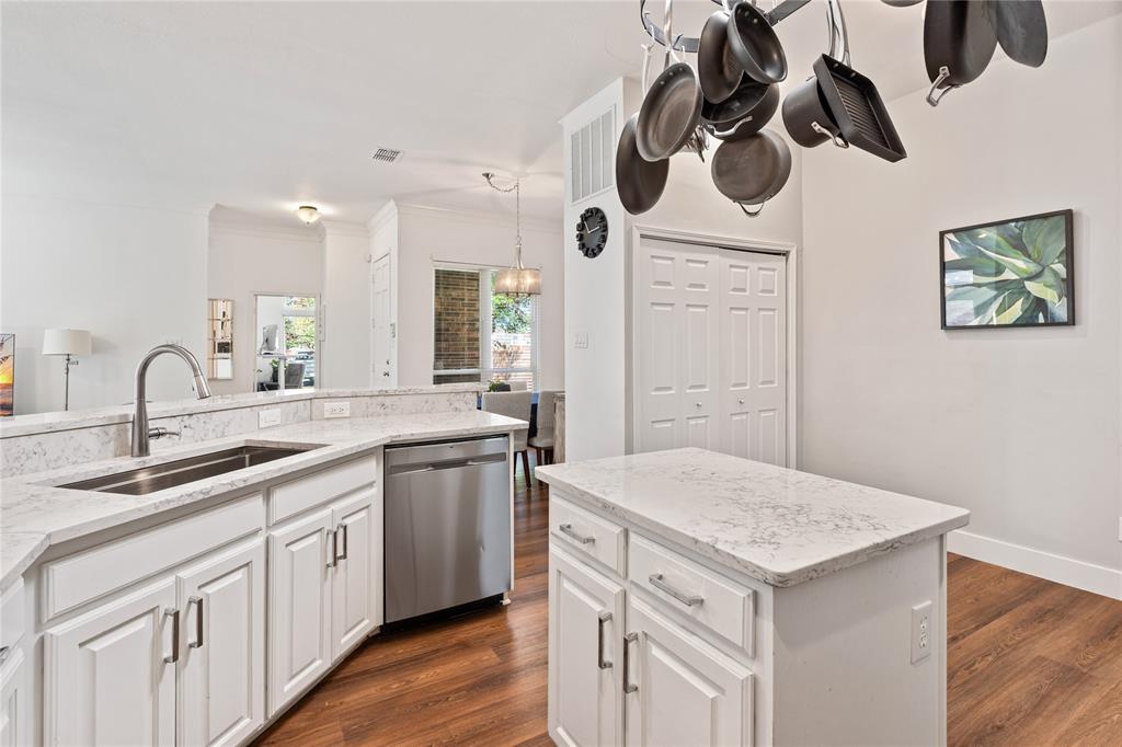 8718 Falls Road Irving, TX 75063 - Photo 13 of 28 a kitchen with a sink a kitchen island with wooden cabinets