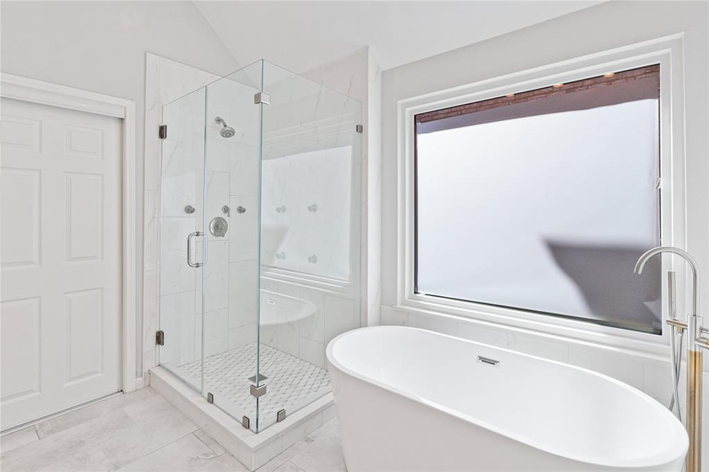 8718 Falls Road Irving, TX 75063 - Photo 19 of 28 a bathroom with a tub a shower and a sink