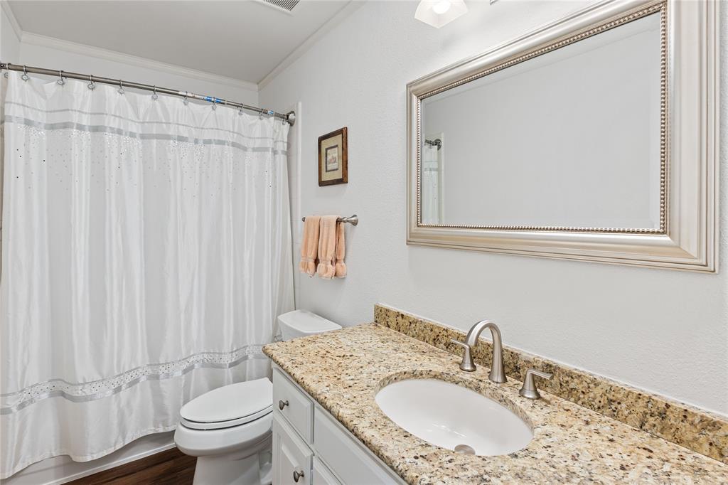 8718 Falls Road Irving, TX 75063 - Photo 22 of 28 a bathroom with a granite countertop sink toilet and a mirror
