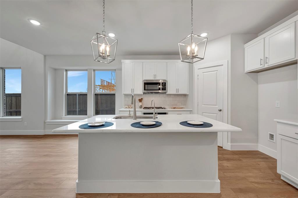2624 Lewisville Road Celina, TX 75009 - Photo 14 of 40 a kitchen with stainless steel appliances kitchen island a table and chairs in it