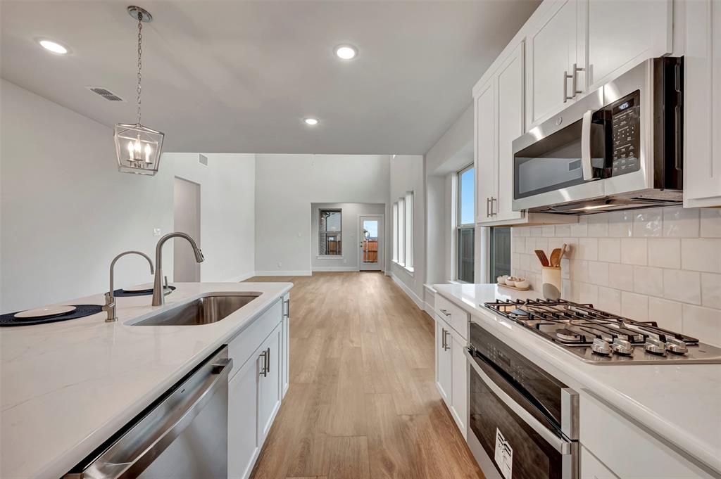 2624 Lewisville Road Celina, TX 75009 - Photo 15 of 40 a kitchen with stainless steel appliances a sink a stove oven a counter space and cabinets