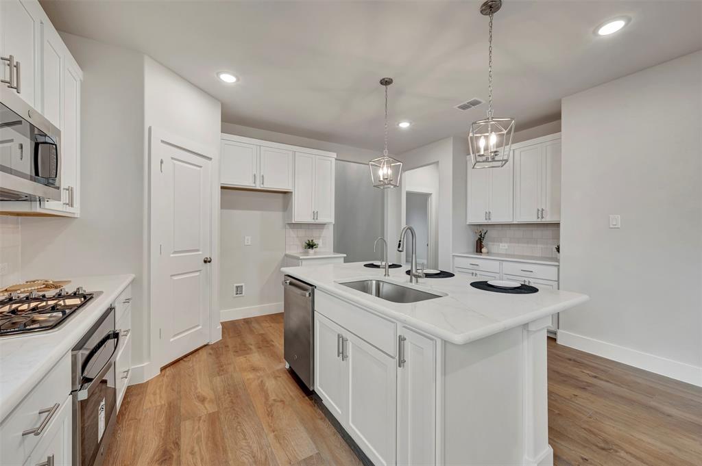 2624 Lewisville Road Celina, TX 75009 - Photo 17 of 40 a kitchen with a sink stove and cabinets