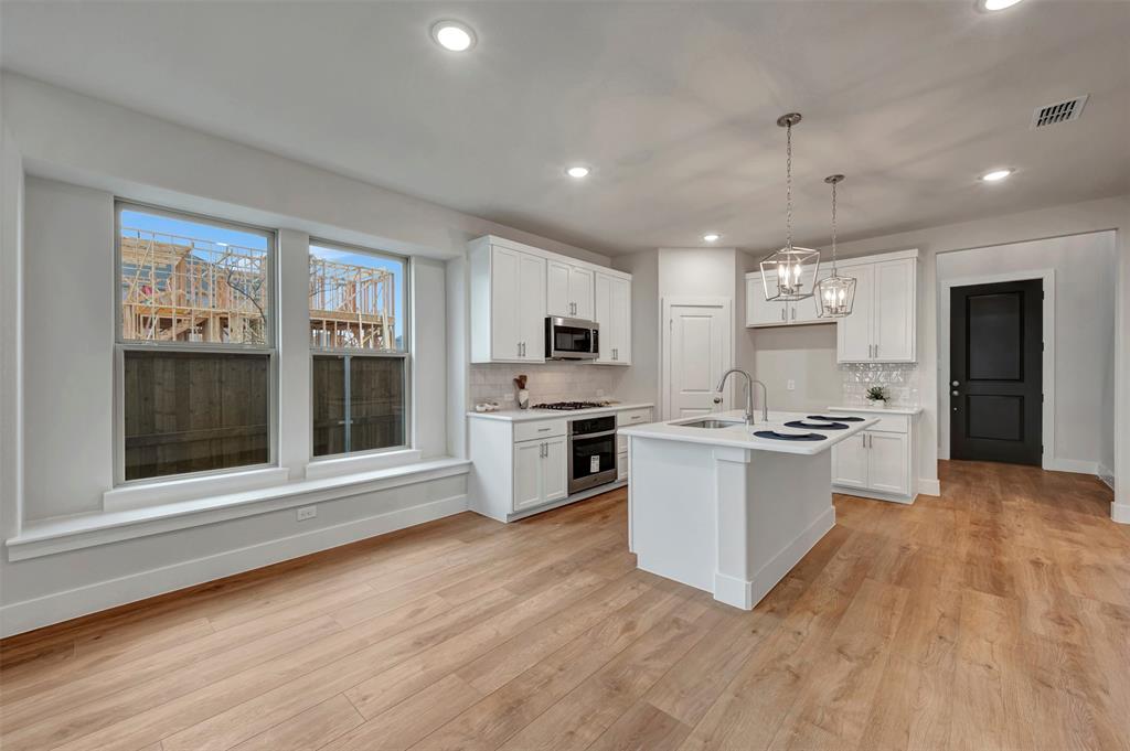 2624 Lewisville Road Celina, TX 75009 - Photo 19 of 40 a large kitchen with kitchen island a sink stainless steel appliances and cabinets