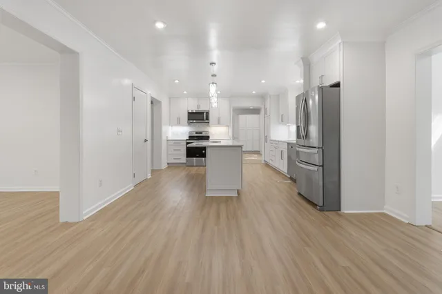 a view of kitchen view wooden floors appliances and cabinets