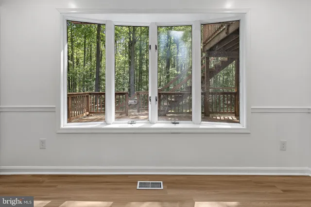 a view of a room that has a window and a ceiling fan