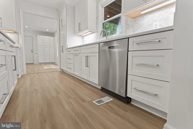 a view of an empty walk in closet with wooden floor