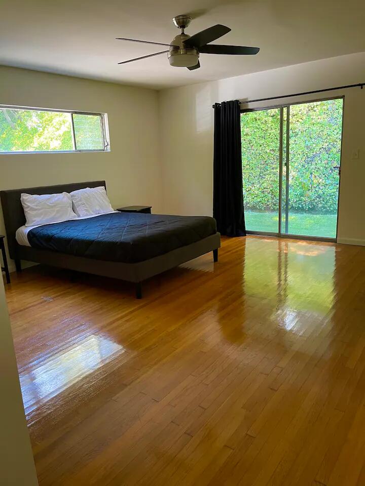 9748 Oak Pass Road Beverly Hills, CA 90210 - Photo 20 of 35 a bedroom with a bed and large windows