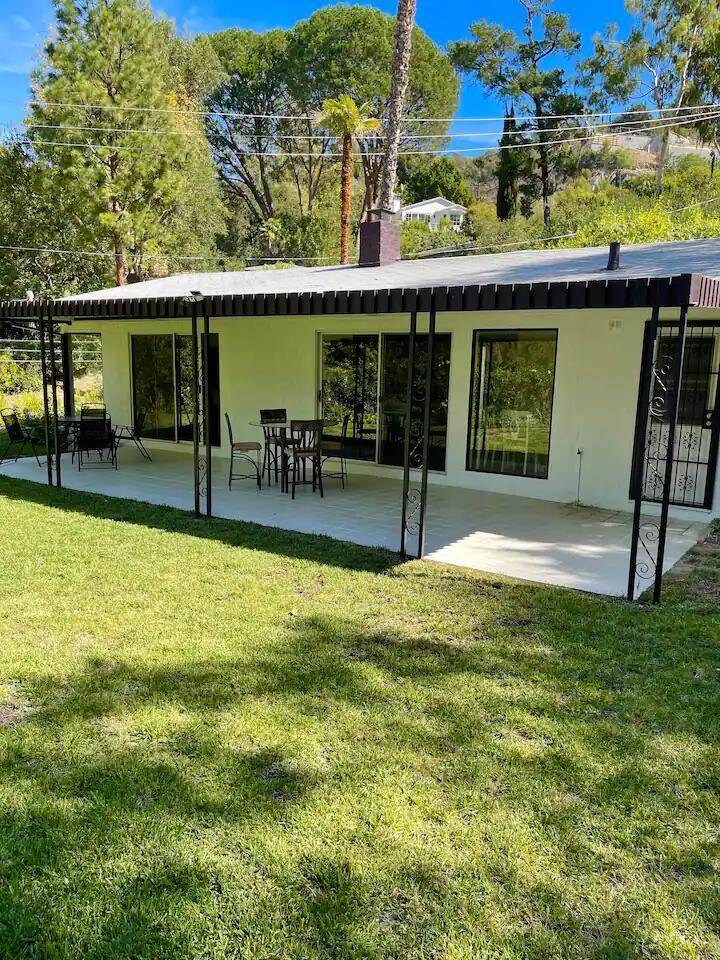 9748 Oak Pass Road Beverly Hills, CA 90210 - Photo 23 of 35 a view of a swimming pool with a lawn chairs under an umbrella
