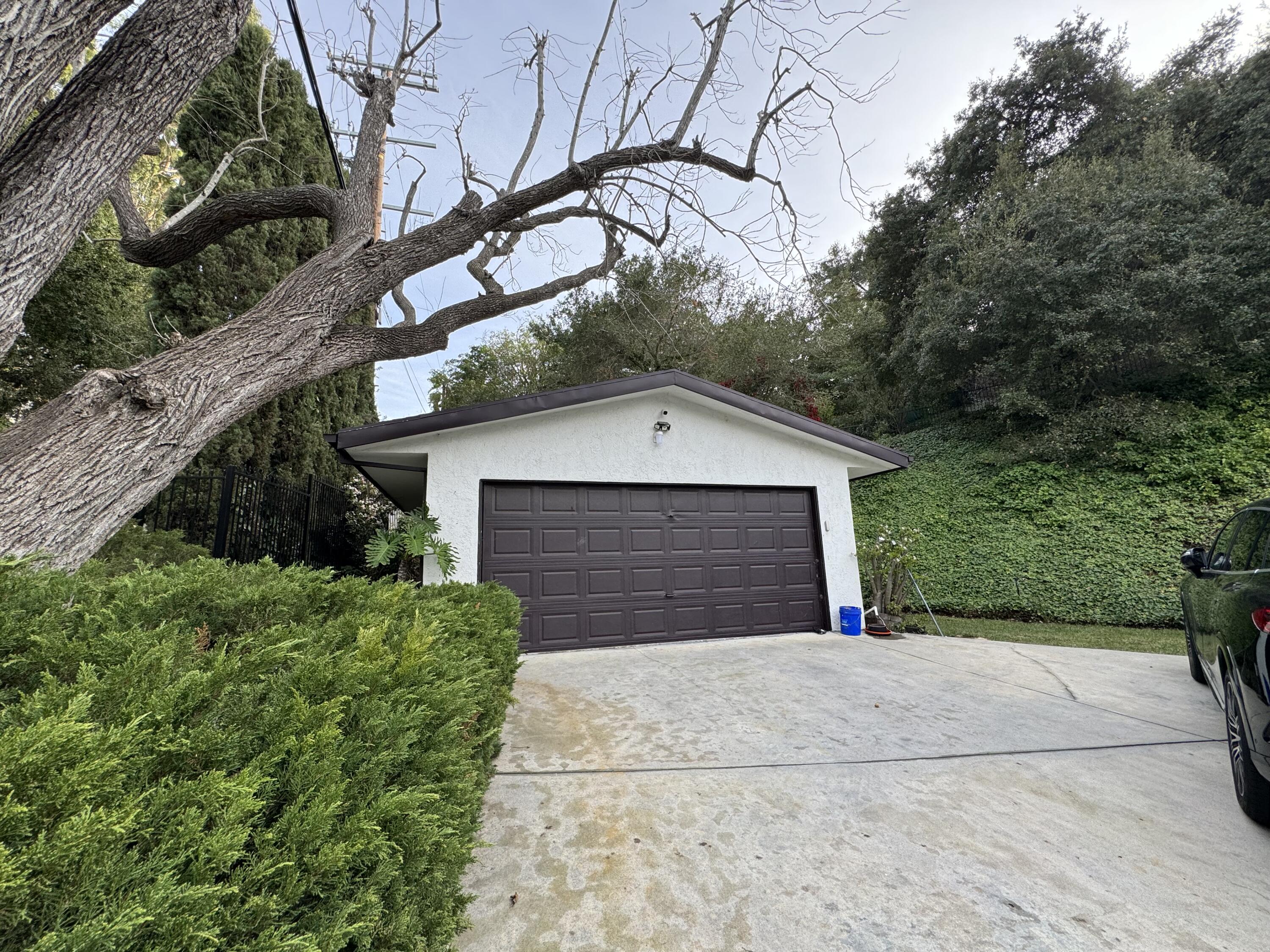 9748 Oak Pass Road Beverly Hills, CA 90210 - Photo 27 of 35 a front view of house with yard garage and green space