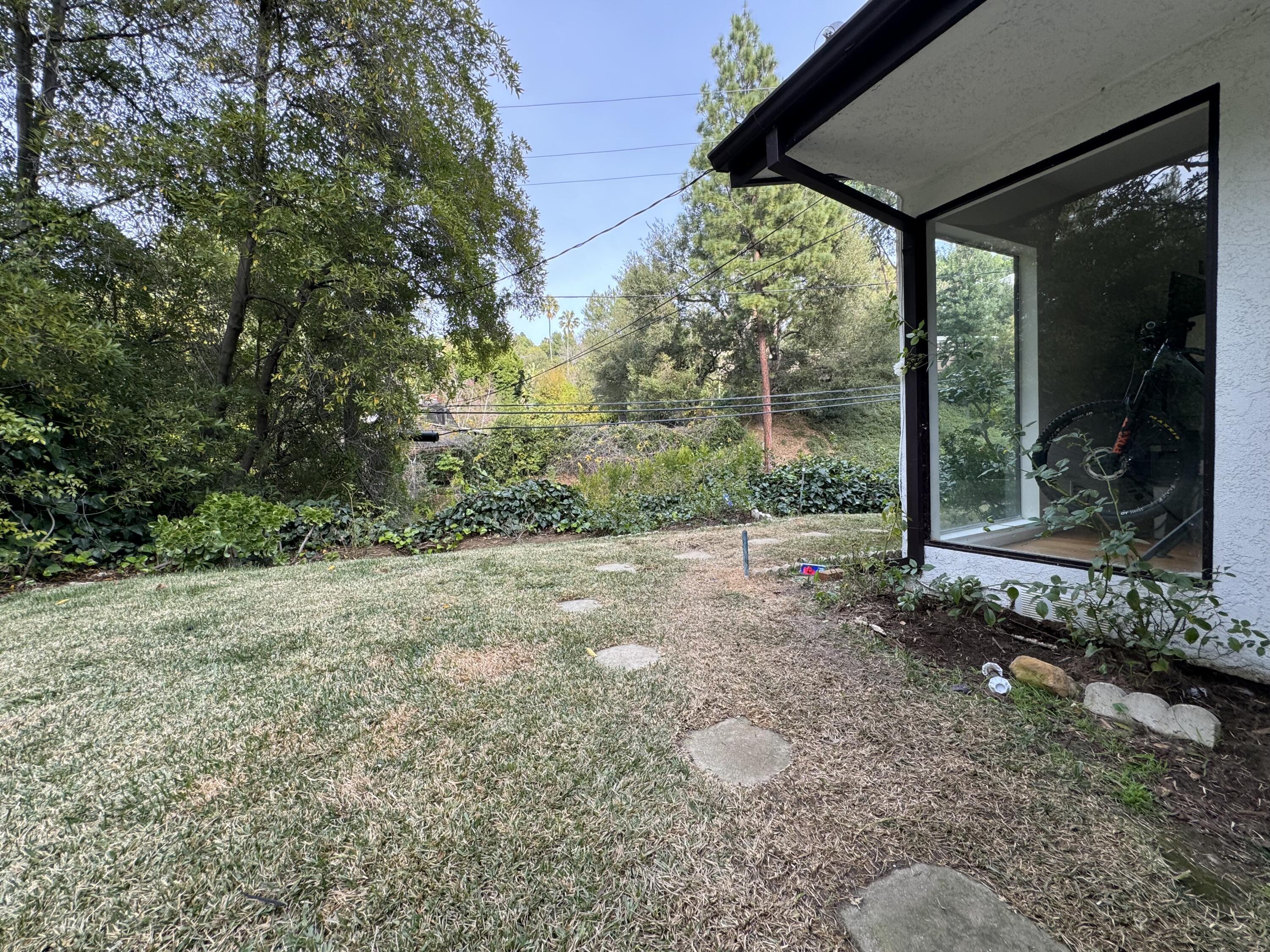 9748 Oak Pass Road Beverly Hills, CA 90210 - Photo 33 of 35 a view of a yard with potted plants and large trees