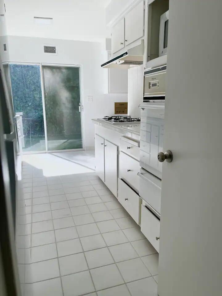 9748 Oak Pass Road Beverly Hills, CA 90210 - Photo 5 of 35 a bathroom with a granite countertop sink a mirror and shower