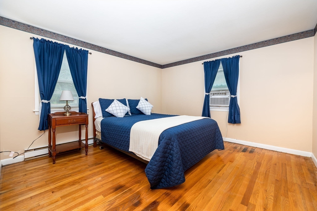 366 Peekskill Avenue Springfield, MA 01129 - Photo 22 of 31 a bedroom with a bed a window and wooden floor