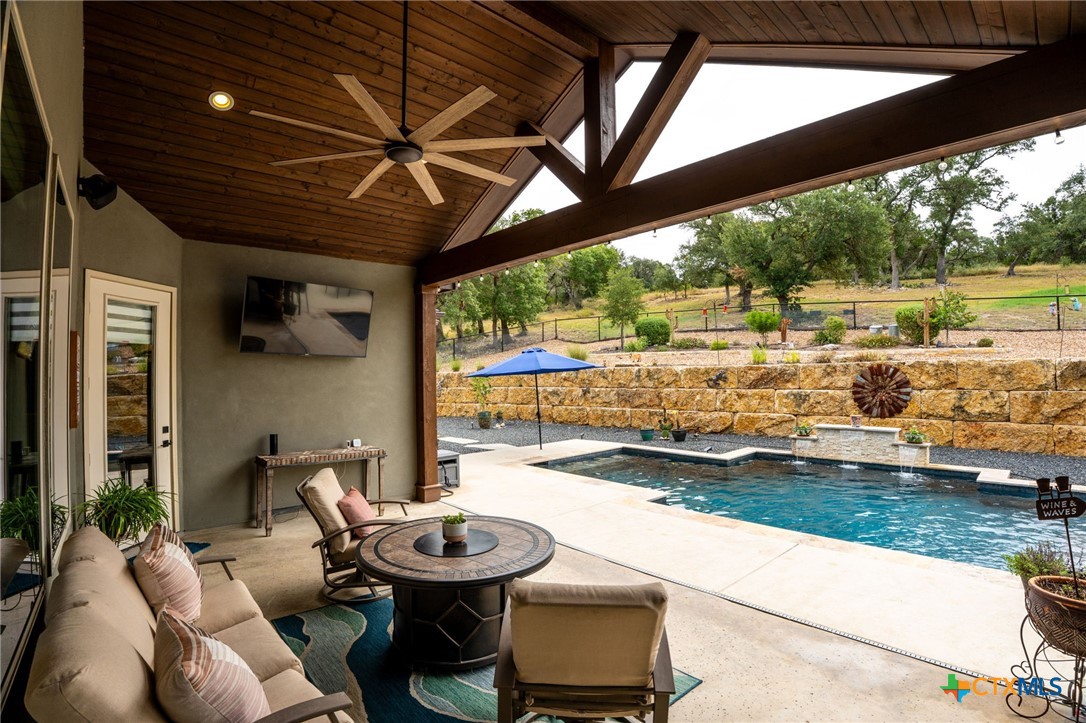 5943 Colin Ridge New Braunfels, TX 78132 - Photo 14 of 37 a living room with patio furniture and a floor to ceiling window next to a yard