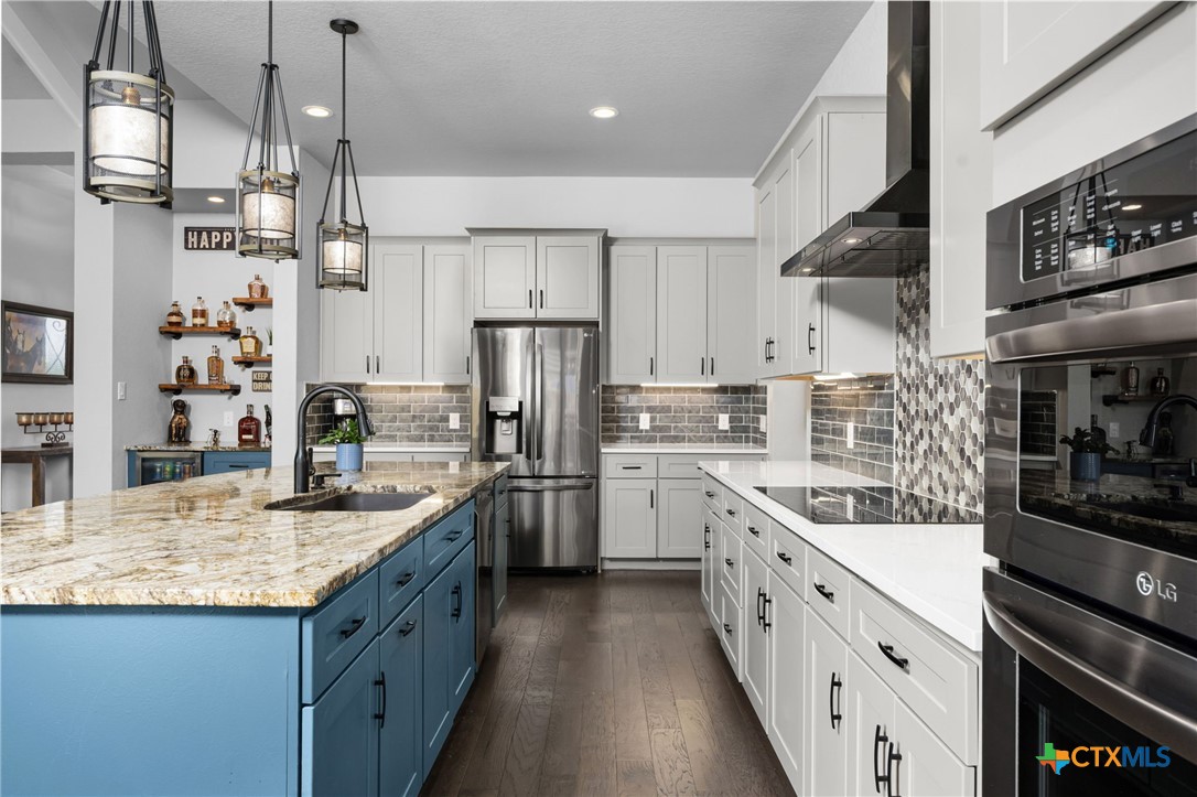 5943 Colin Ridge New Braunfels, TX 78132 - Photo 21 of 37 a kitchen with stainless steel appliances granite countertop a sink refrigerator and cabinets