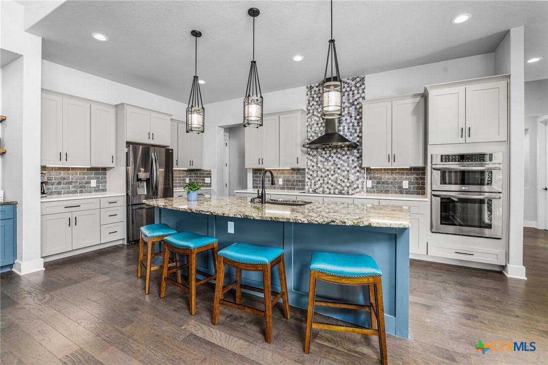 5943 Colin Ridge New Braunfels, TX 78132 - Photo 22 of 37 a kitchen with kitchen island granite countertop a table and chairs in it