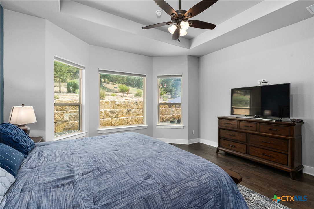 5943 Colin Ridge New Braunfels, TX 78132 - Photo 25 of 37 a bedroom with a large bed and a flat screen tv