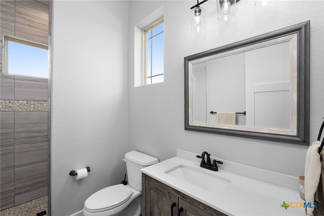 5943 Colin Ridge New Braunfels, TX 78132 - Photo 30 of 37 a bathroom with a sink a toilet and mirror