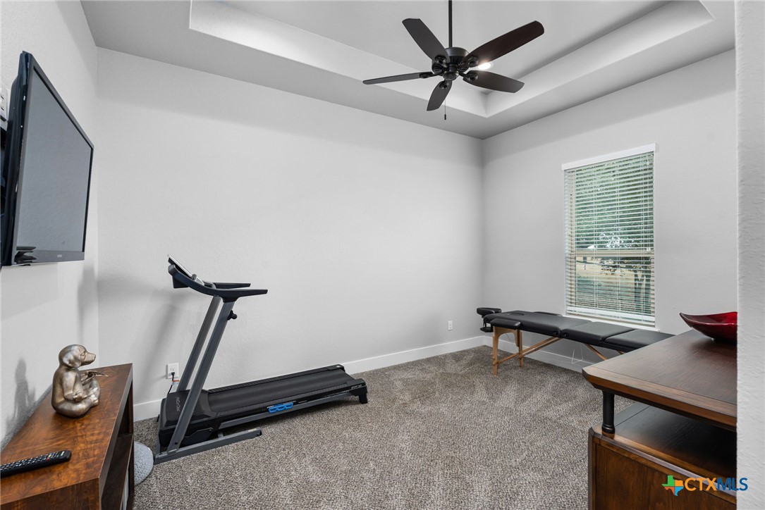 5943 Colin Ridge New Braunfels, TX 78132 - Photo 33 of 37 a room with gym equipment and a flat screen tv