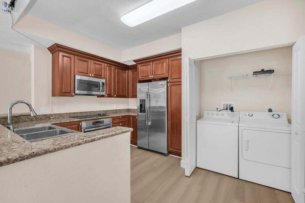 1690 Renaissance Commons Boulevard, Unit 1219 Boynton Beach, FL 33426 - Photo 13 of 38 a kitchen with stainless steel appliances granite countertop a refrigerator sink and stove