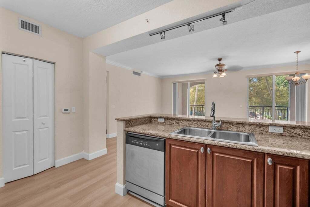 1690 Renaissance Commons Boulevard, Unit 1219 Boynton Beach, FL 33426 - Photo 17 of 38 a bathroom with a granite countertop sink a mirror and a window