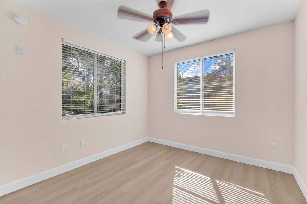 1690 Renaissance Commons Boulevard, Unit 1219 Boynton Beach, FL 33426 - Photo 20 of 38 a view of an empty room with a window and a chandelier fan