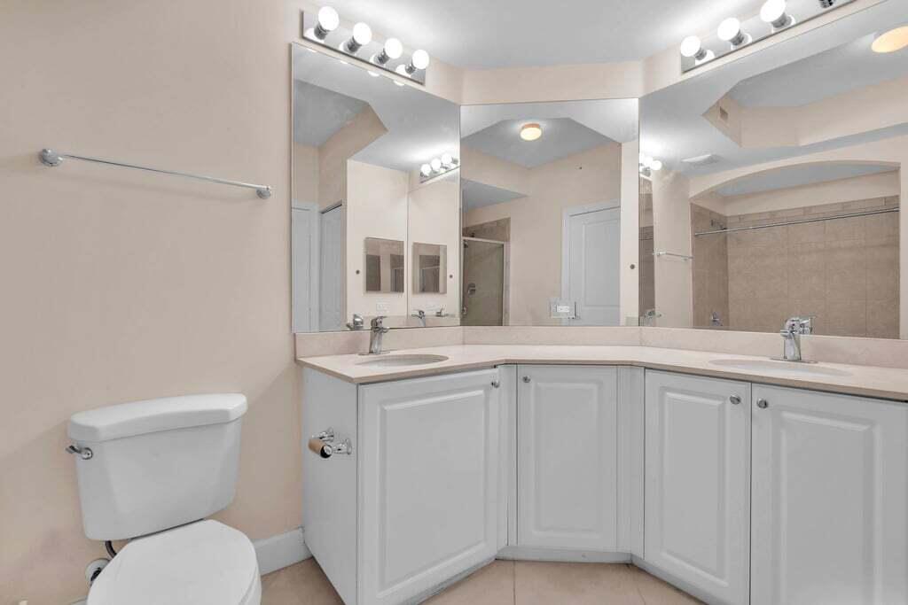 1690 Renaissance Commons Boulevard, Unit 1219 Boynton Beach, FL 33426 - Photo 30 of 38 a bathroom with a toilet sink and mirror
