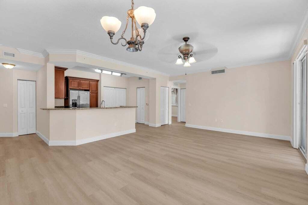 1690 Renaissance Commons Boulevard, Unit 1219 Boynton Beach, FL 33426 - Photo 6 of 38 a view of a livingroom with a chandelier fan and wooden floor
