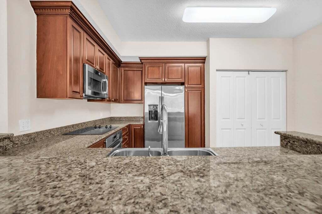 1690 Renaissance Commons Boulevard, Unit 1219 Boynton Beach, FL 33426 - Photo 7 of 38 a view of a kitchen with a sink and cabinets