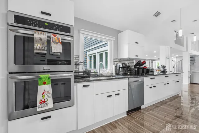 a kitchen with stainless steel appliances granite countertop a stove and a sink