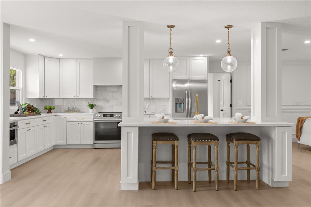 206 Graham Road Fern Park, FL 32730 - Photo 4 of 34 a kitchen with stainless steel appliances granite countertop a sink a stove a refrigerator and white cabinets