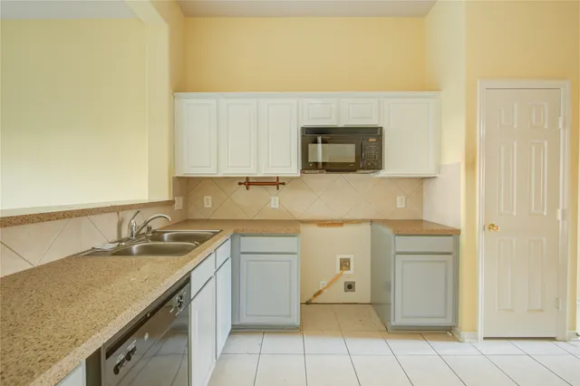 a kitchen with a sink and a stove top oven