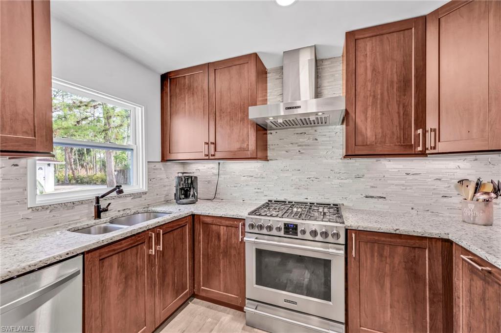 3231 13th Avenue Southwest Naples, FL 34117 - Photo 11 of 49 a kitchen with a sink stove top oven and cabinets