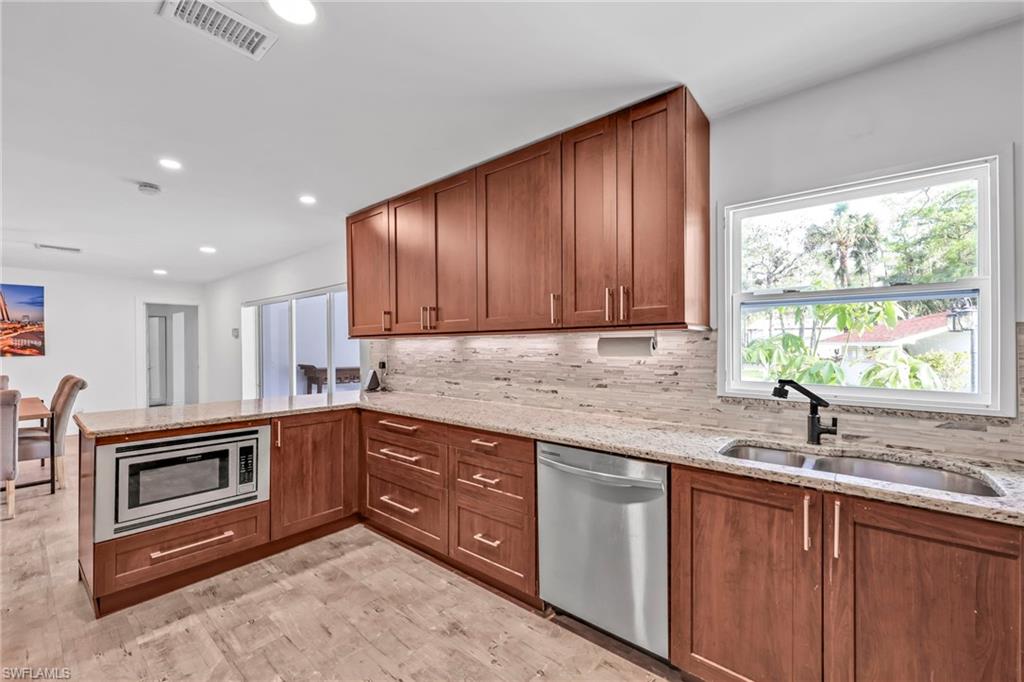 3231 13th Avenue Southwest Naples, FL 34117 - Photo 12 of 49 a kitchen with granite countertop cabinets sink and window